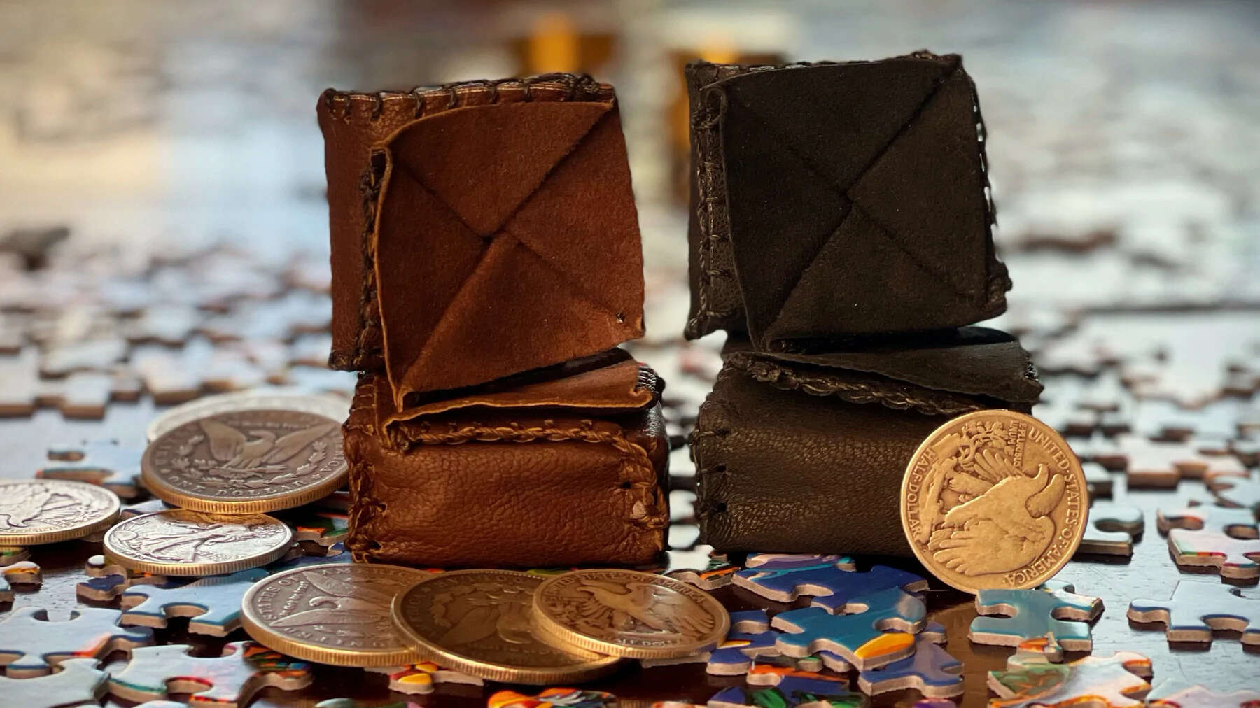 Coin Box Wallet by Jeff Copeland brown and black next to coins on jigsaw pieces