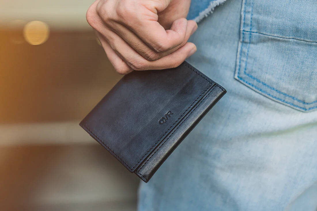 Modern Z Wallet Pro 2.0 by Patrick Kun held in left hand at waist height by man in blue jeans