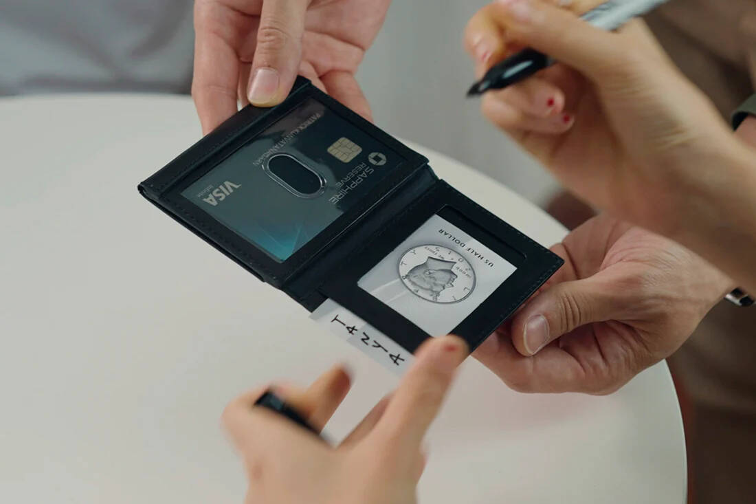 Modern Z Wallet Pro 2.0 by Patrick Kun held open in 2 hands with another person holding a sharpie