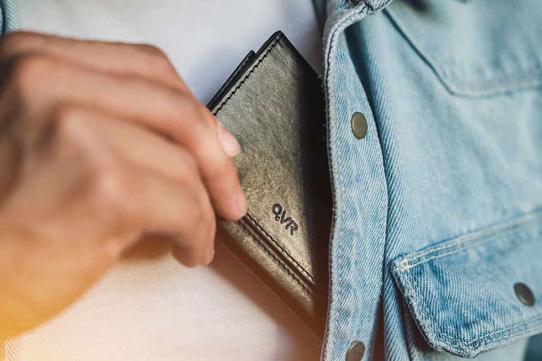 Modern Z Wallet Pro 2.0 by Patrick Kun being place in blue denim jacket with right hand