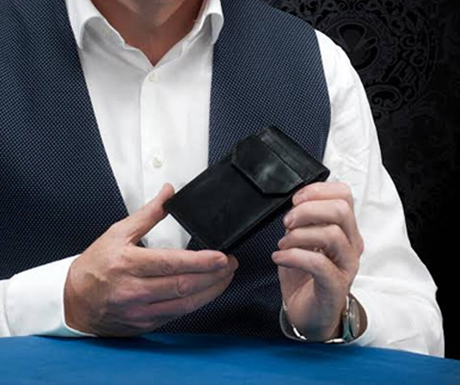Multi Wallet by Leo Smetsers held in both hands by man in waistcoat and white shirt sat at blue table