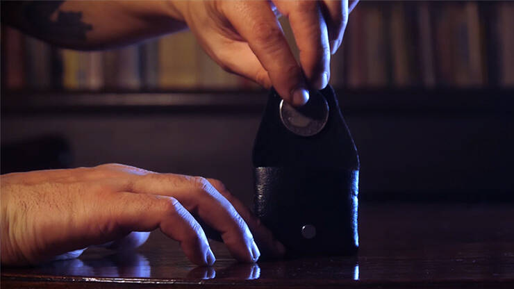 The Fooler Wallet by Eric Roumestan standing upright with coin being placed inside by magician