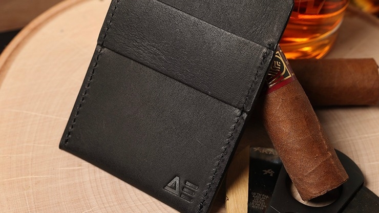Wallet by Nicholas Lawrence next to cigar cutter, cigars and alcohol