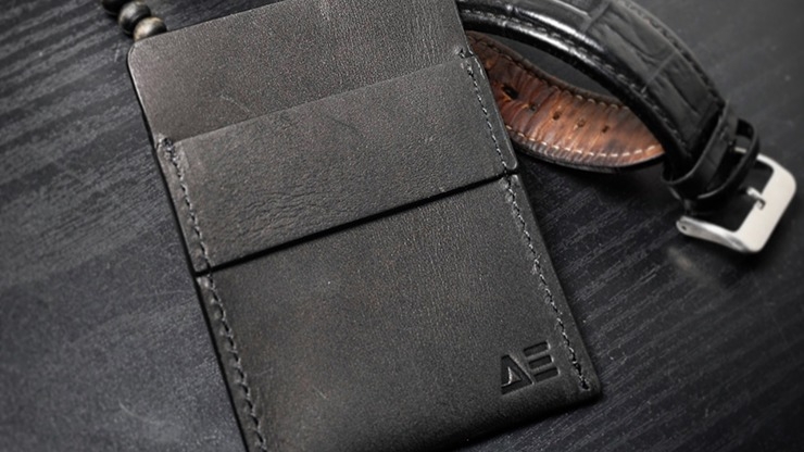 Wallet by Nicholas Lawrence next to belt on black surface