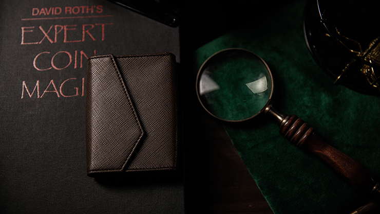 Luxury Leather Playing Card Carrier by TCC browwn on top of boo and next to magnifying glass